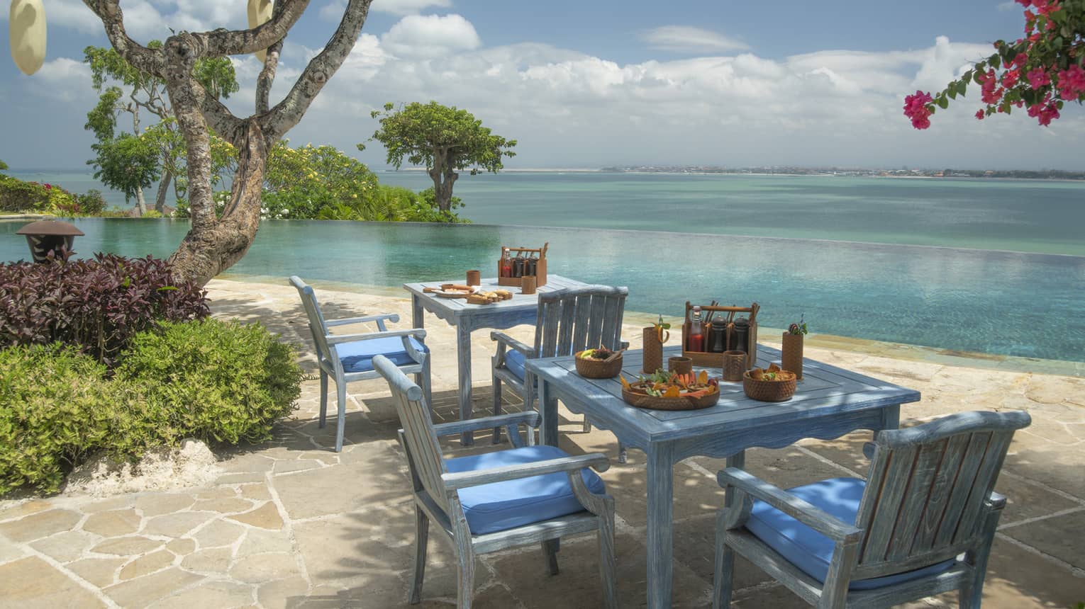 Alu Restaurant blue tables and chairs on flagstone patio directly on beach