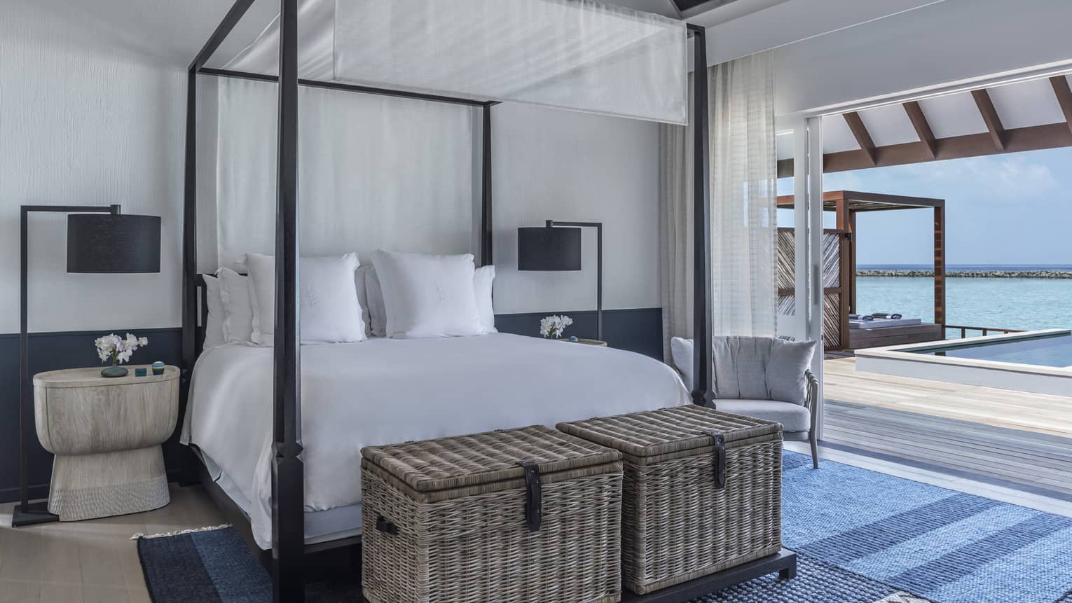 Sunrise Water Villa with Pool bedroom with four-poster bed, doorway opening onto deck with pool