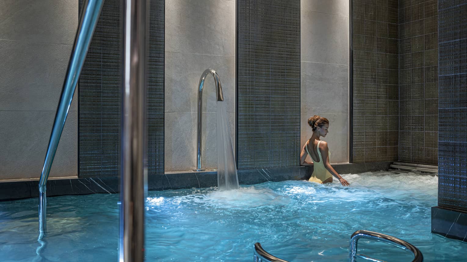 Woman in yellow bathing suit soaks in the Spa's vitality pool