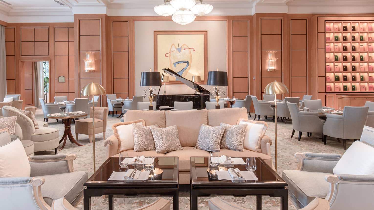 Large lobby with multiple neutral seating areas, black baby grand piano, modern art on wall