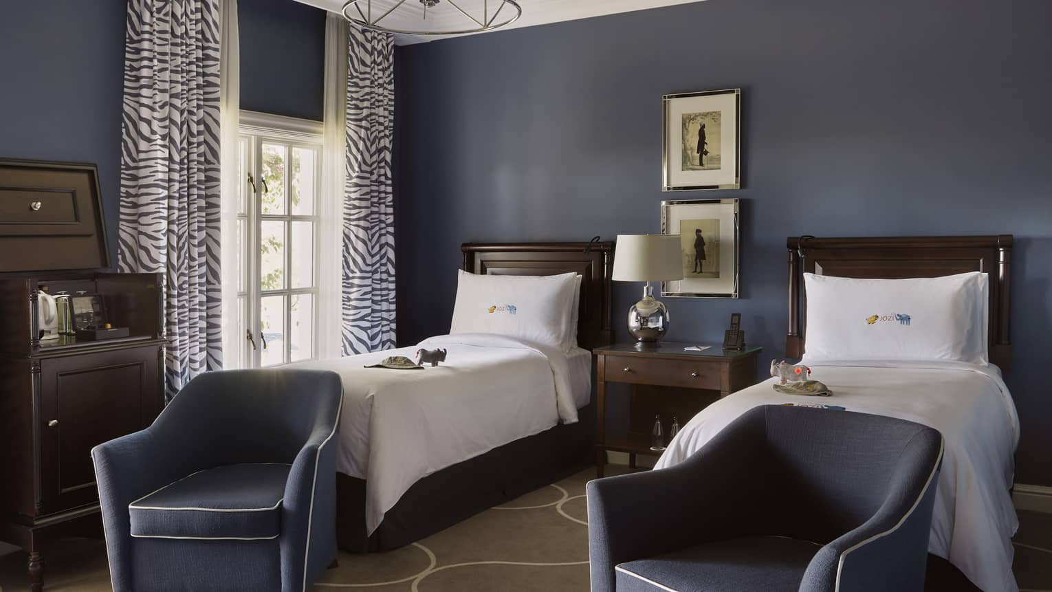 Hotel room with two twin beds and two arm chairs