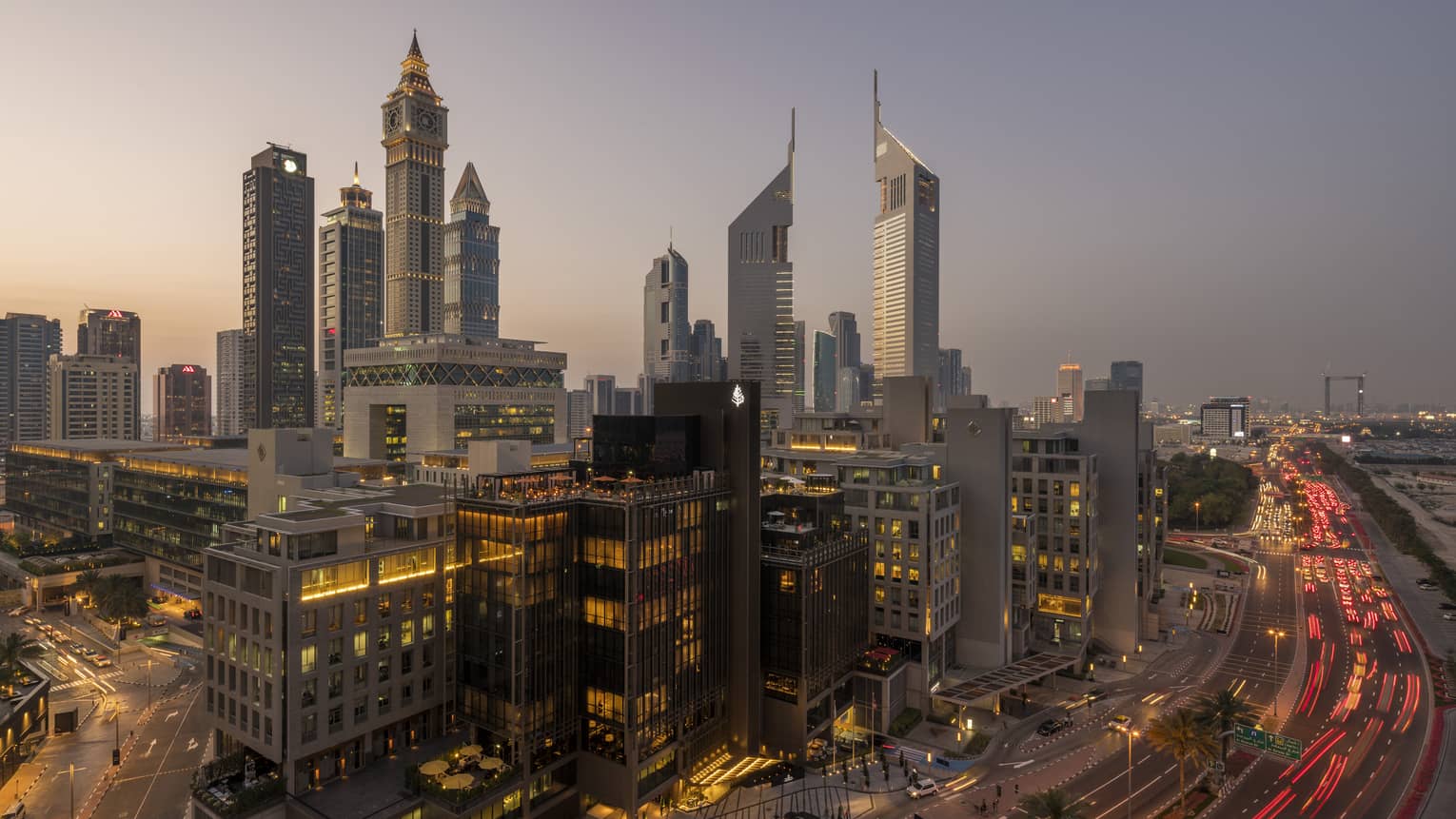 Aerial view of Dubai city skyline, road, lights around Four Seasons International Financial Centre hotel at sunset