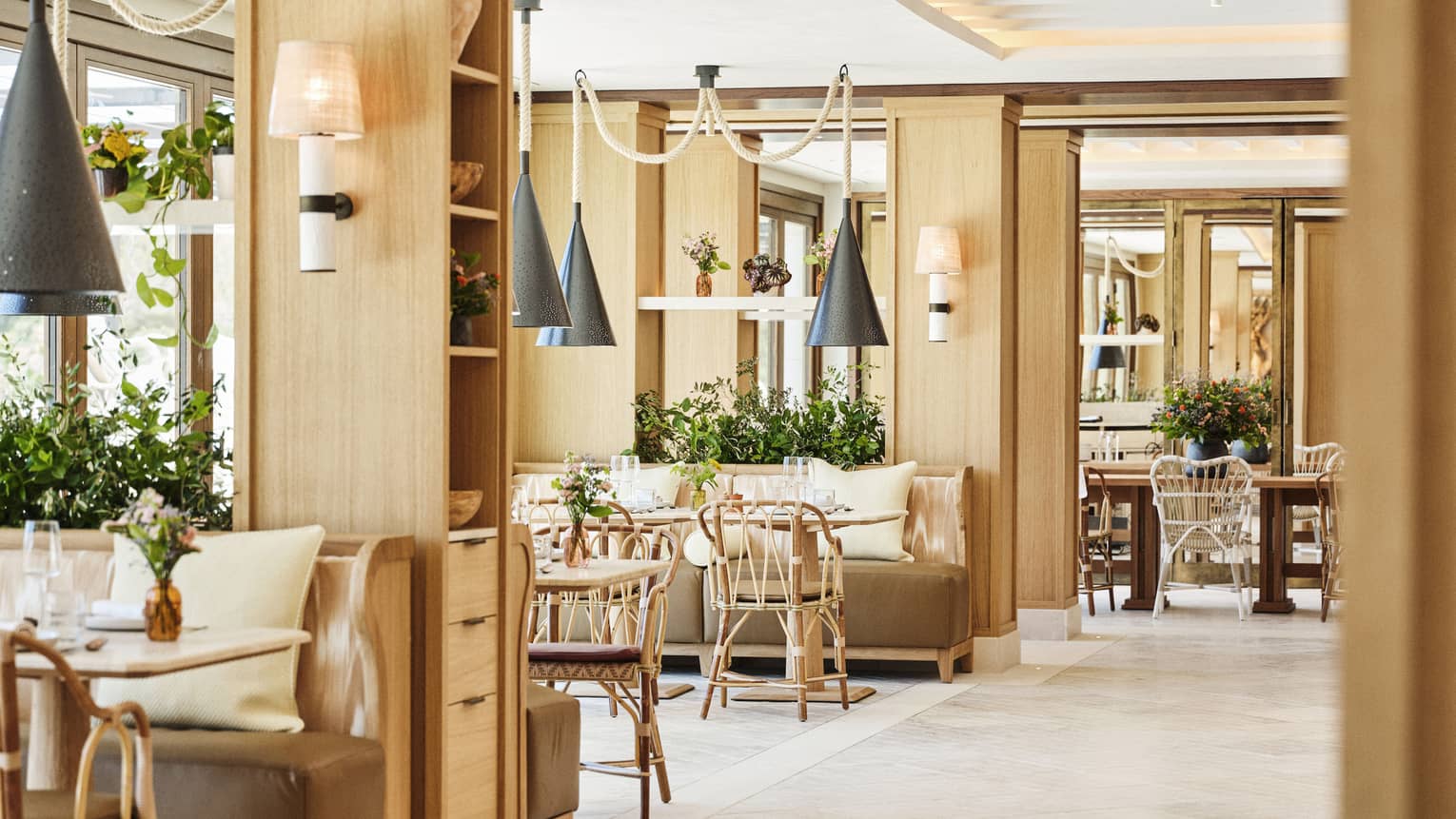 Light-filled restaurant Mel at Four Seasons Resort Mallorca, featuring natural furnishings and hanging metal lights