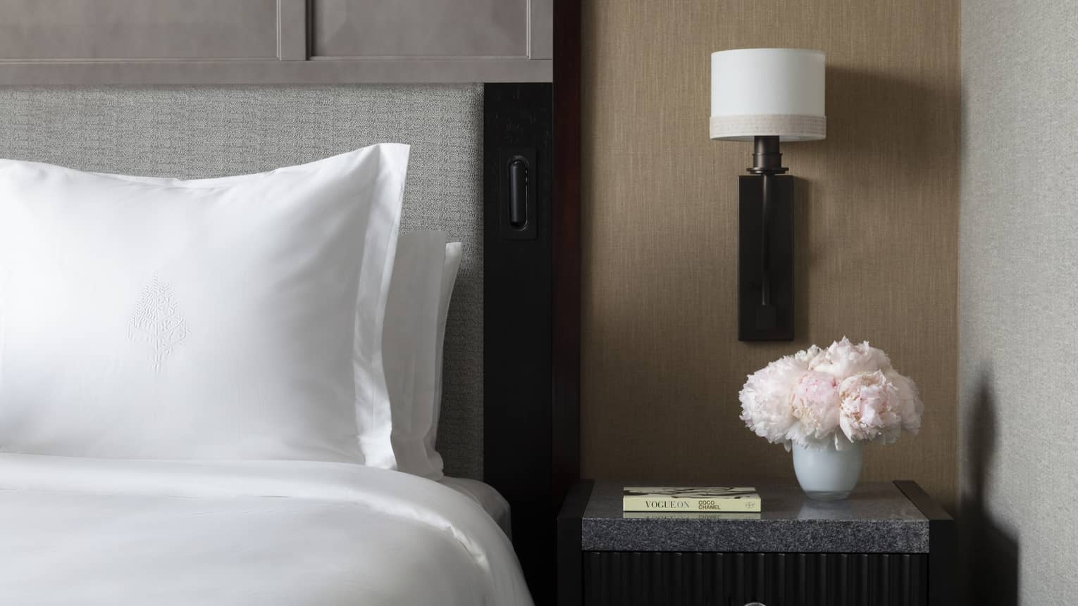 Sleek bedside table next to a crisp white Four Seasons bed