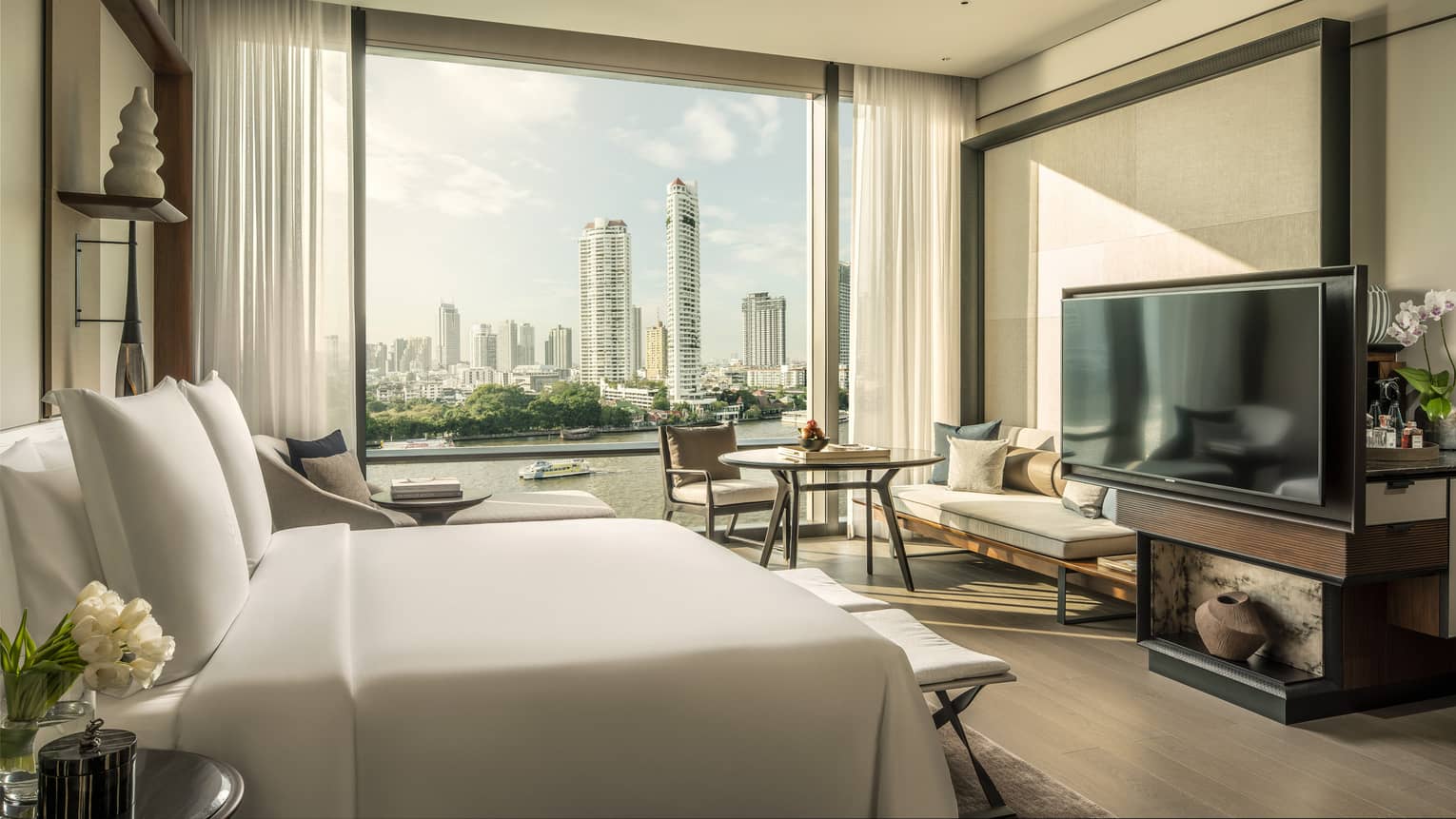 Hotel room with white king bed, view of Chao Phraya River, TV