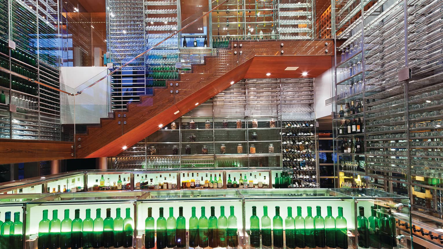 San Qi restaurant two-level glass room with walls of wine racks, glasses, wood staircase down to bar 