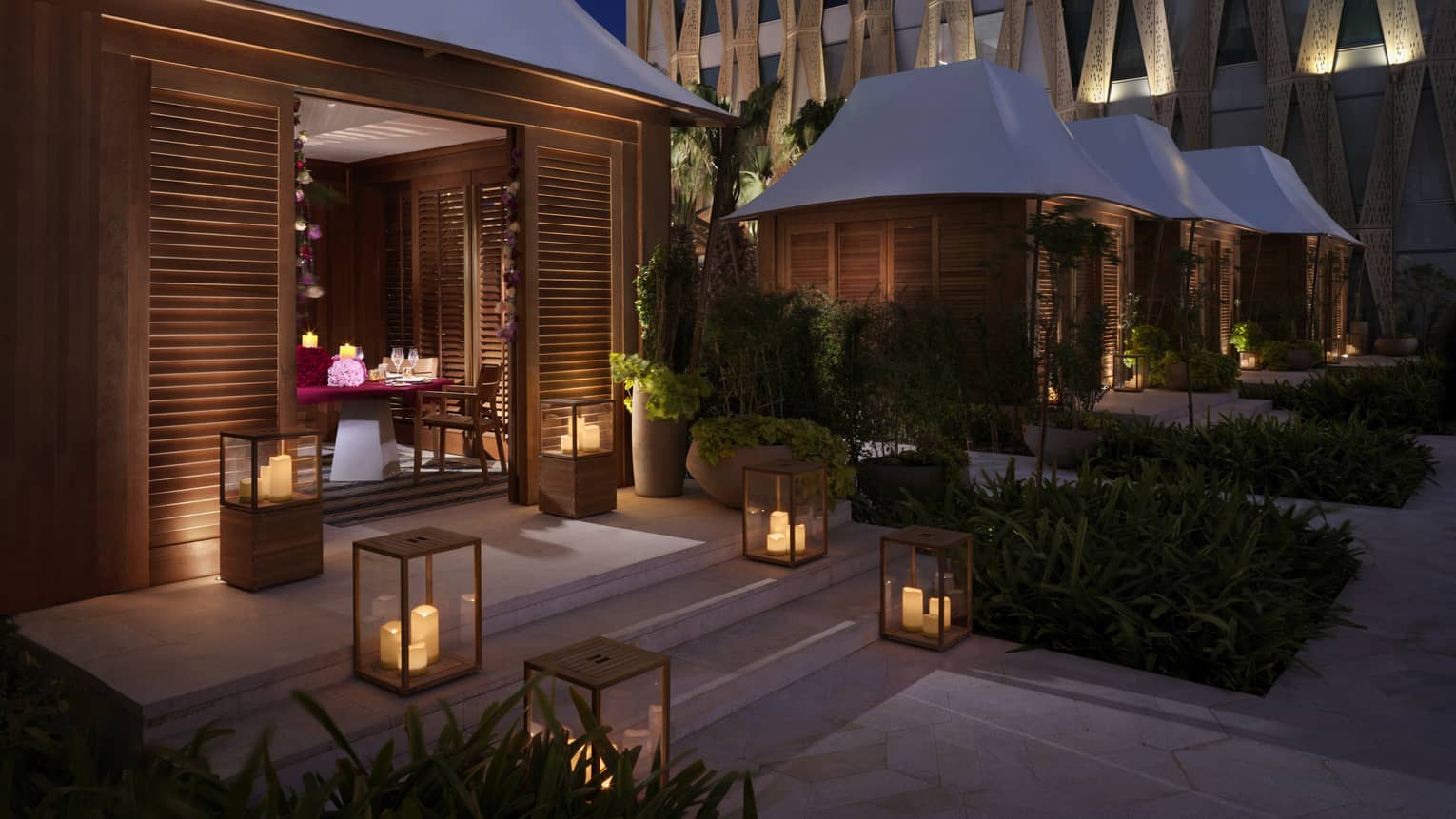 A series of lanterns illuminating the steps into a private bungalow