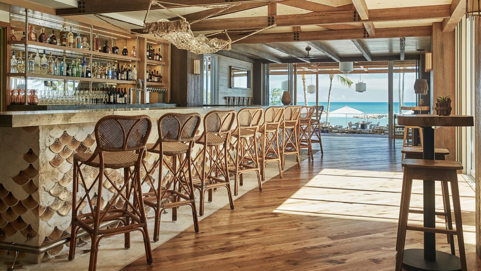Wicker stools line Minas bar with wood fish-scale design, under fish net hammock with glass balls