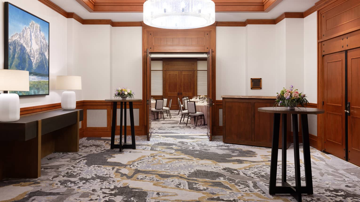 A waiting area with standing tables, lamps, and a large ceiling light.