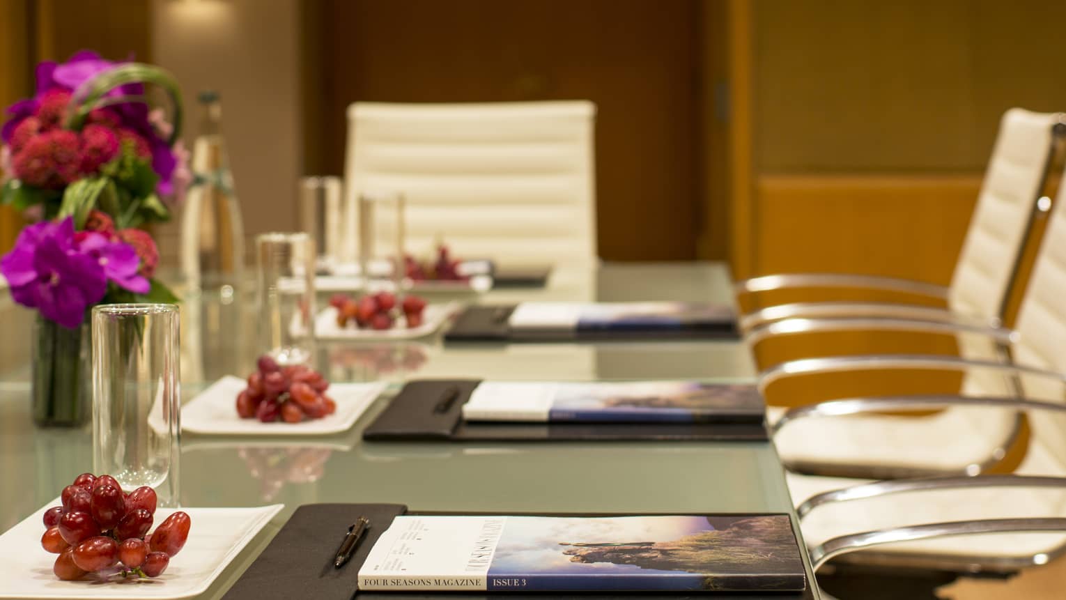 Boardroom meeting table with red grapes on white plates