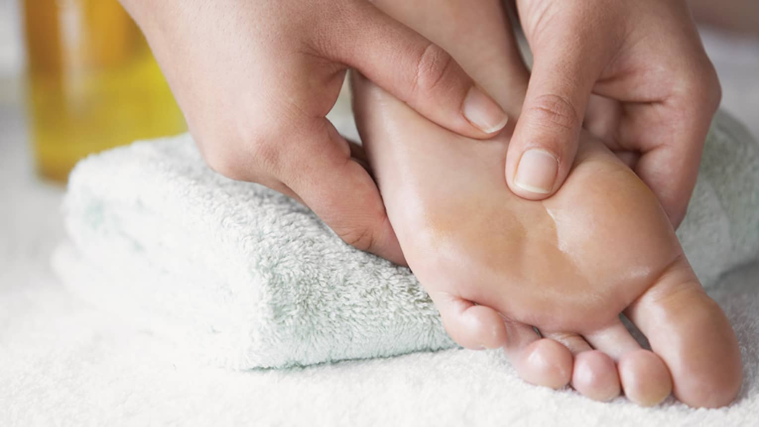 Close-up of hands massaging pressure points on feet