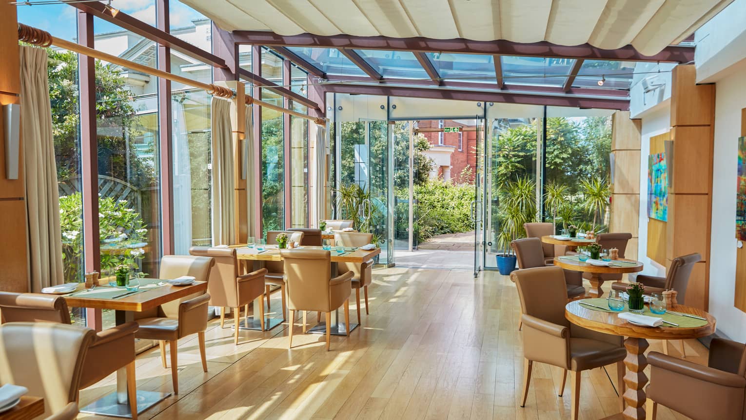 Light-filled restaurant with hardwood floors and brown leather chairs
