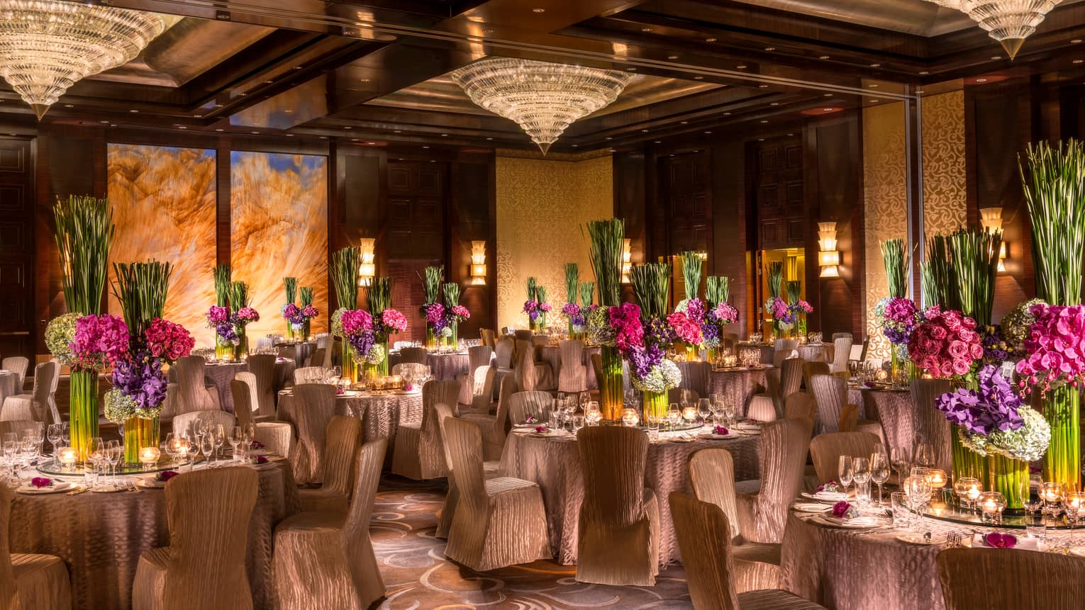 Imperial Ballroom wedding reception with fabric-covered chairs, floral centrepieces, crystal chandeliers