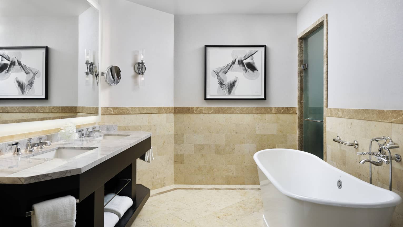 Double marbled vanity with two sinks, full-width mirror, large soaking tub, tiled wall at chair rail