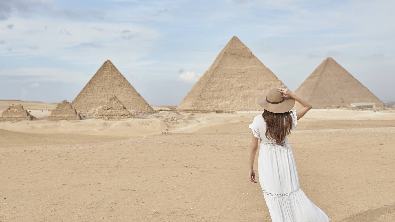 A guest wearing a linen dress observing the Great Pyramids