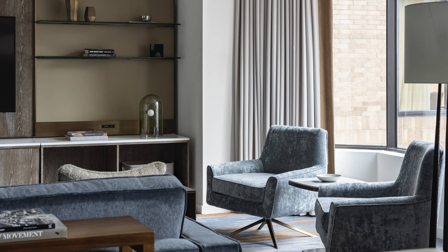 Residence at Four Seasons Hotel Houston, with shelving unit and light-blue chairs and couch near window