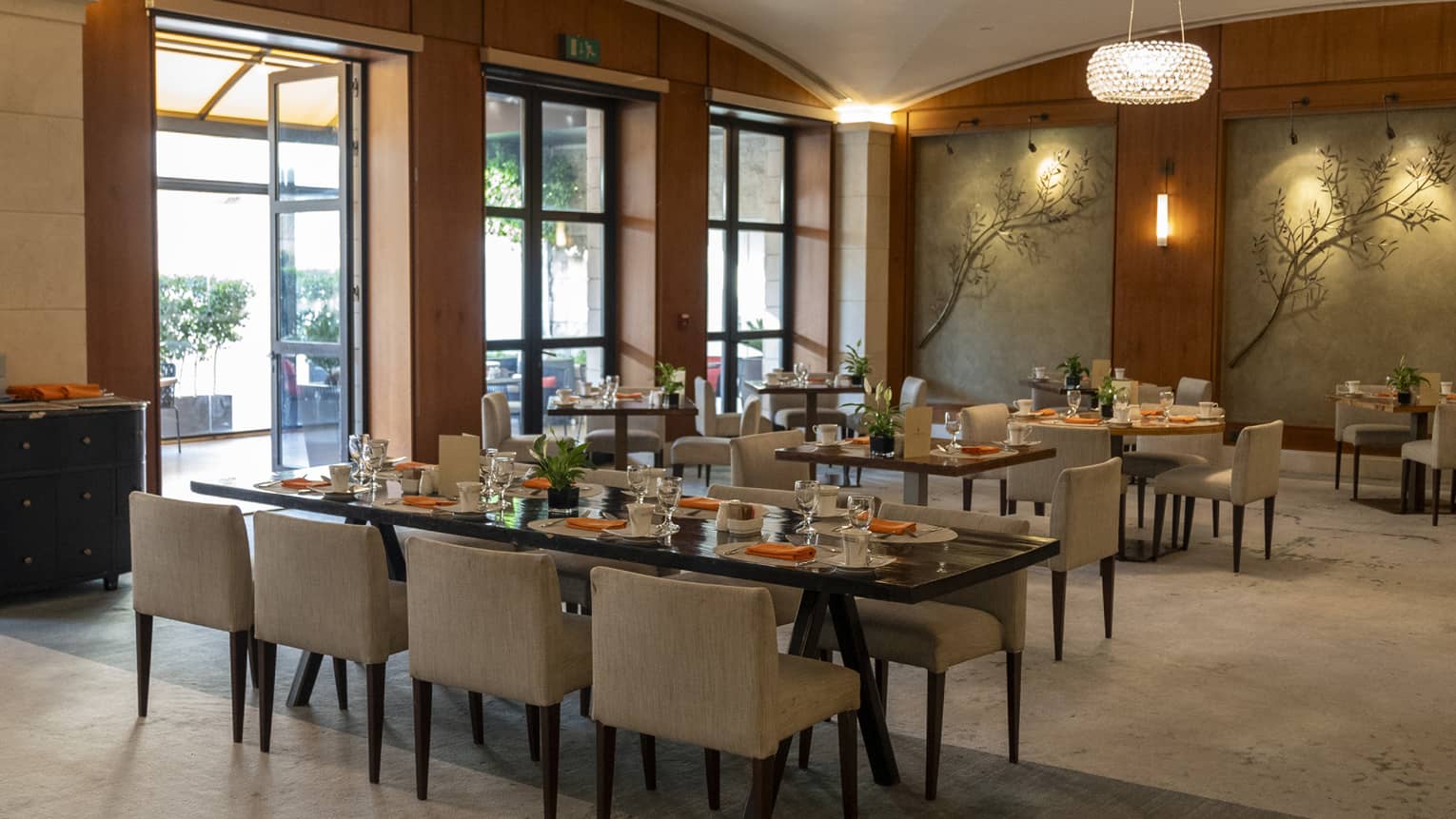 Restaurant dining room with tables next to a wall of windows