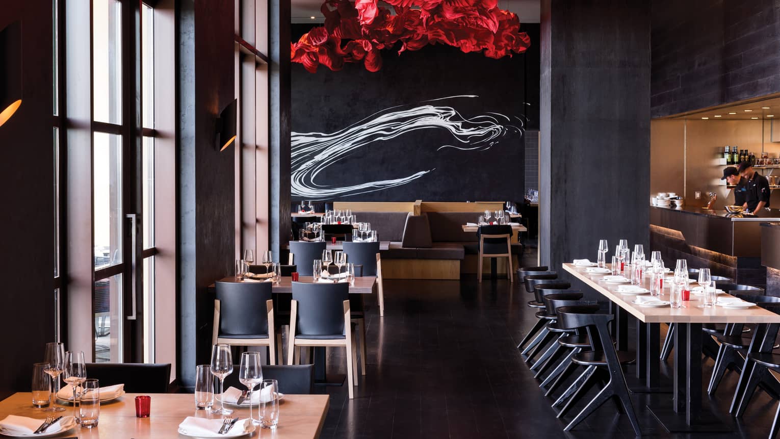 A red sculpture on the ceiling and red and white accents illuminate the Capa dining room
