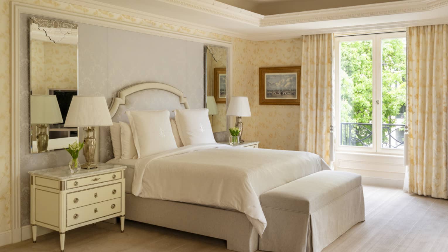 Elegant hotel suite bedroom with king bed, crown molding and bench