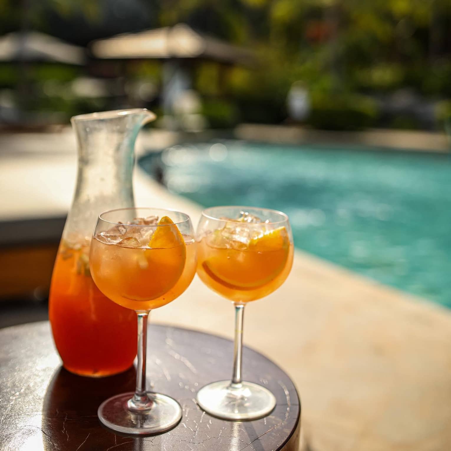 Two citrus cocktails served by the pool