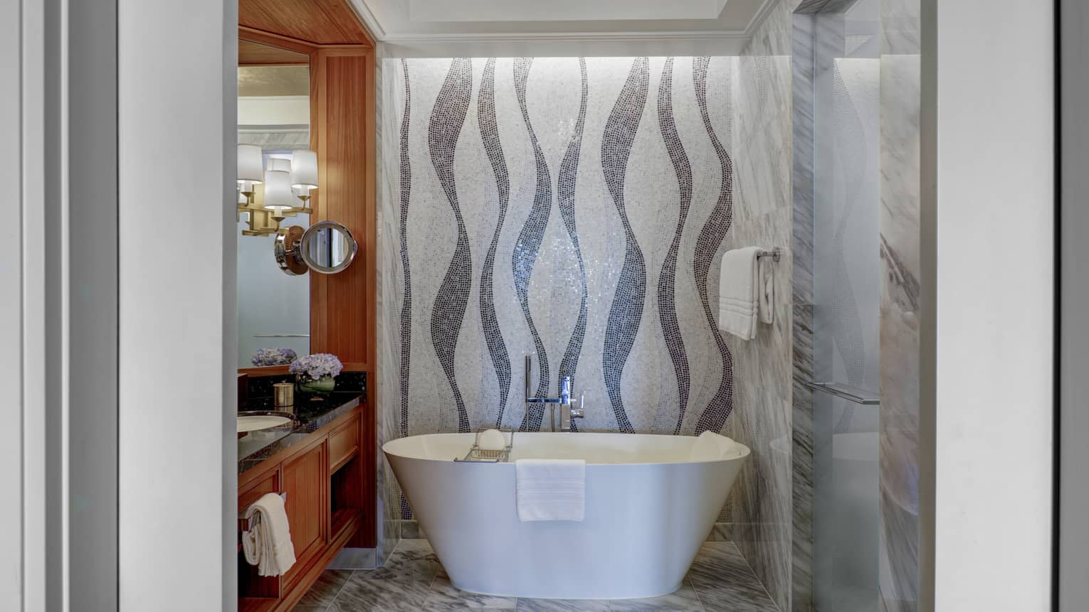 Bathroom with mosaic tiled wall, freestanding white tub