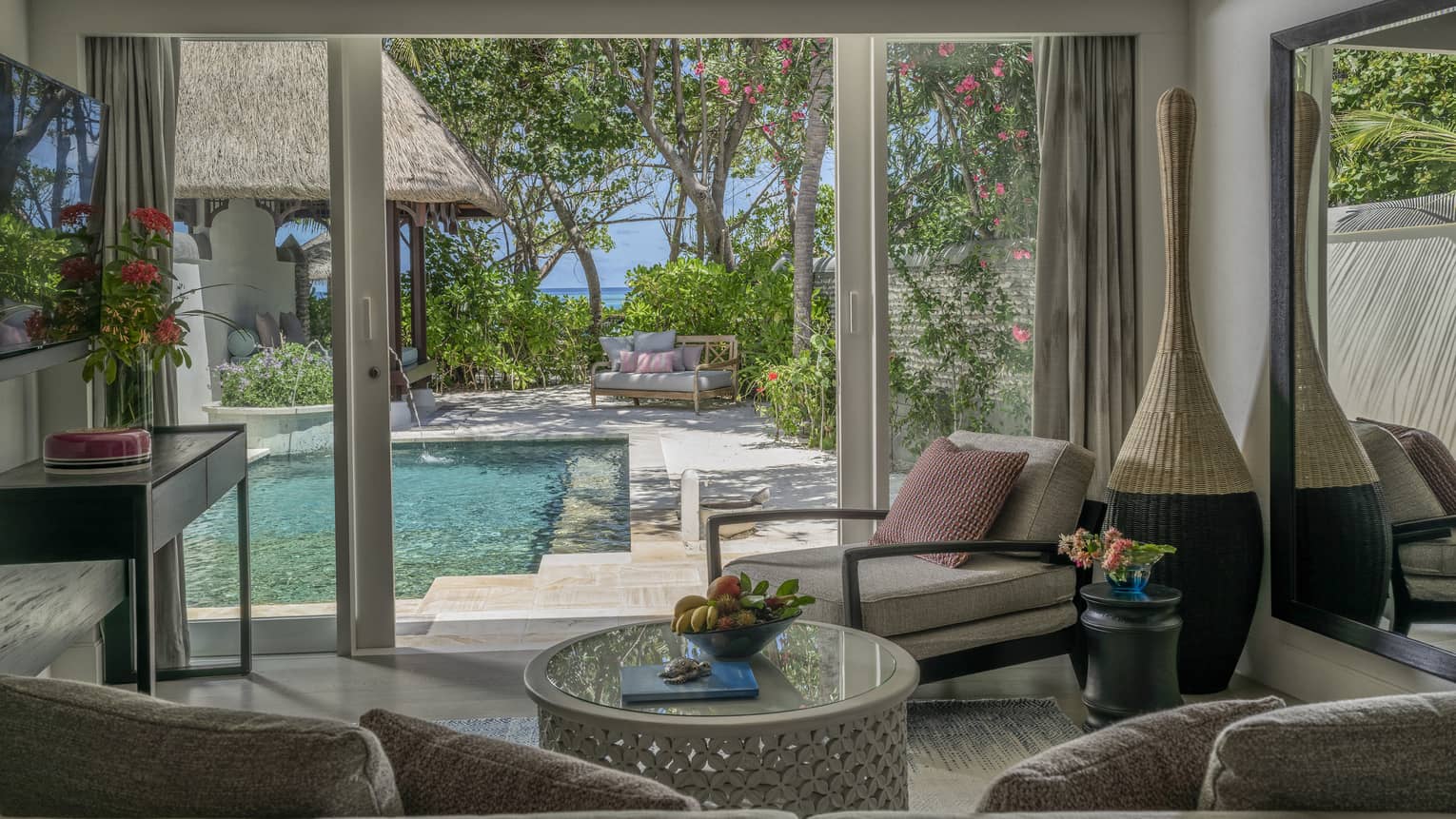 Living room opening to pool deck, with beach in the distance