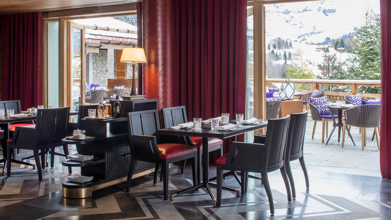 Kaito dining tables, chairs by deep red pillar, curtains, open glass doors to patio