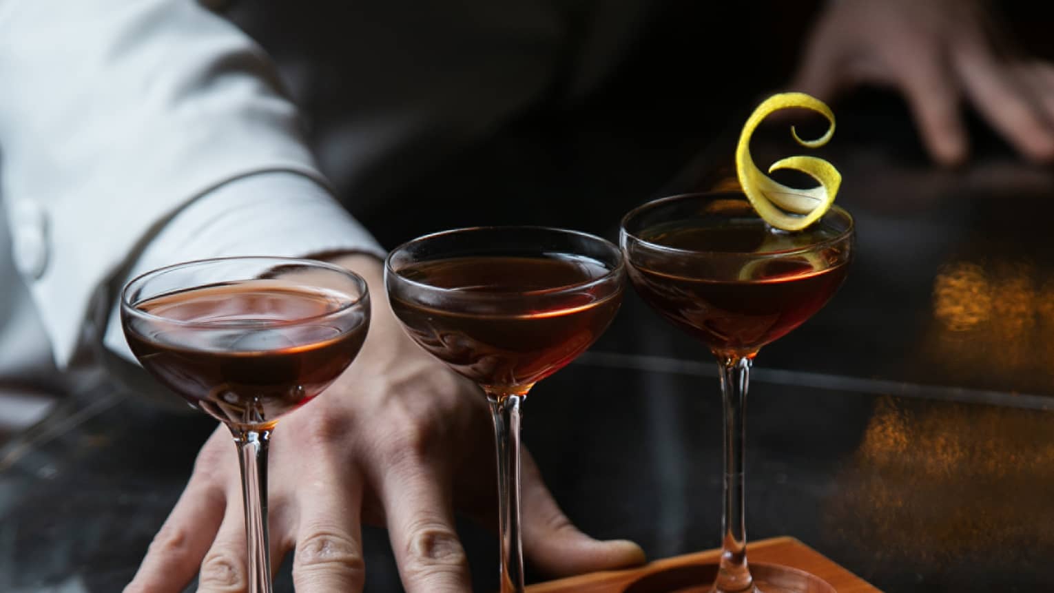 Row of three cocktails ? Classic Manhattan, De La Louisiane and Vieux Carr� ? in wooden stand