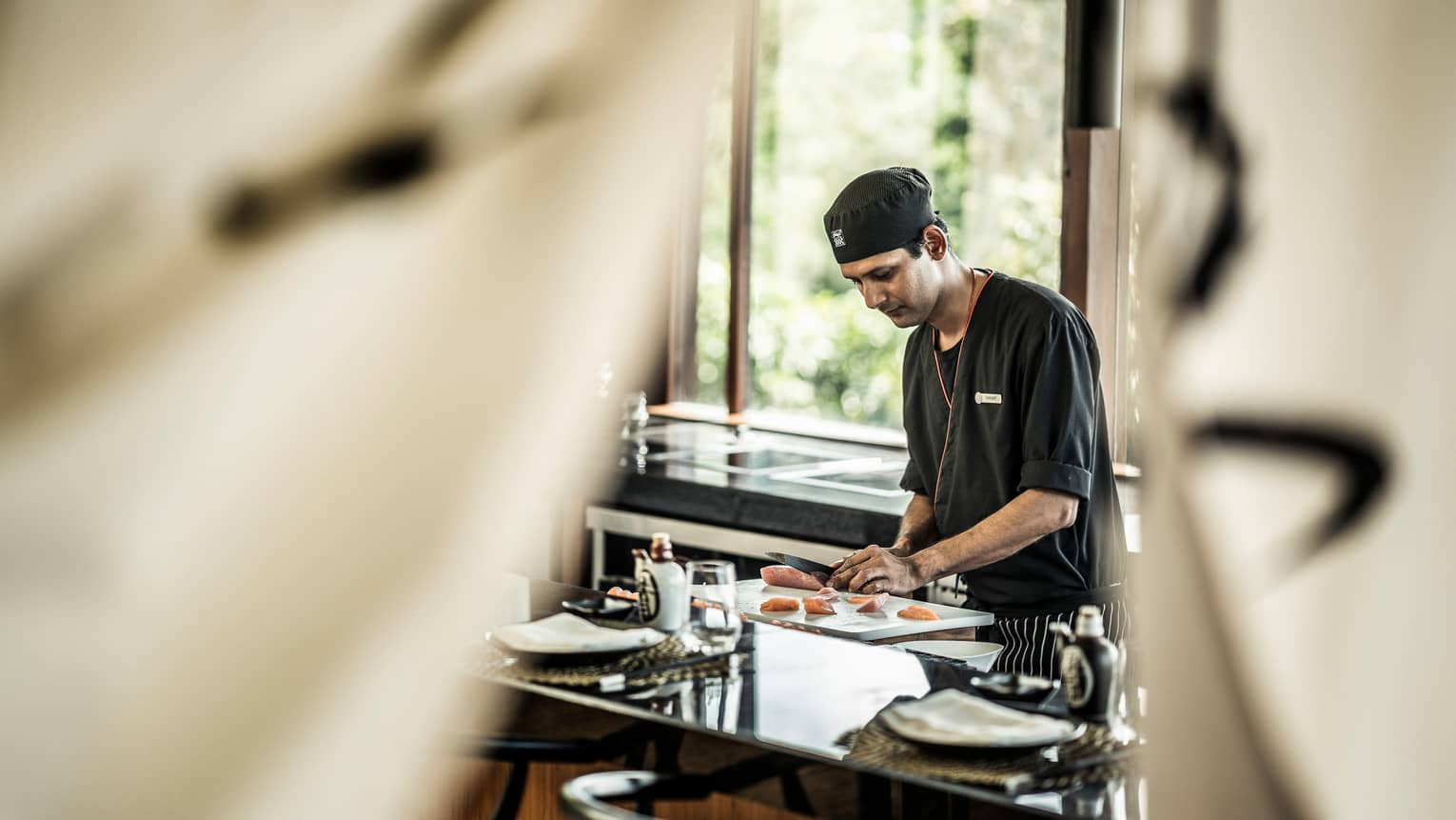 KOI chef prepares sushi at counter in brightly lit room