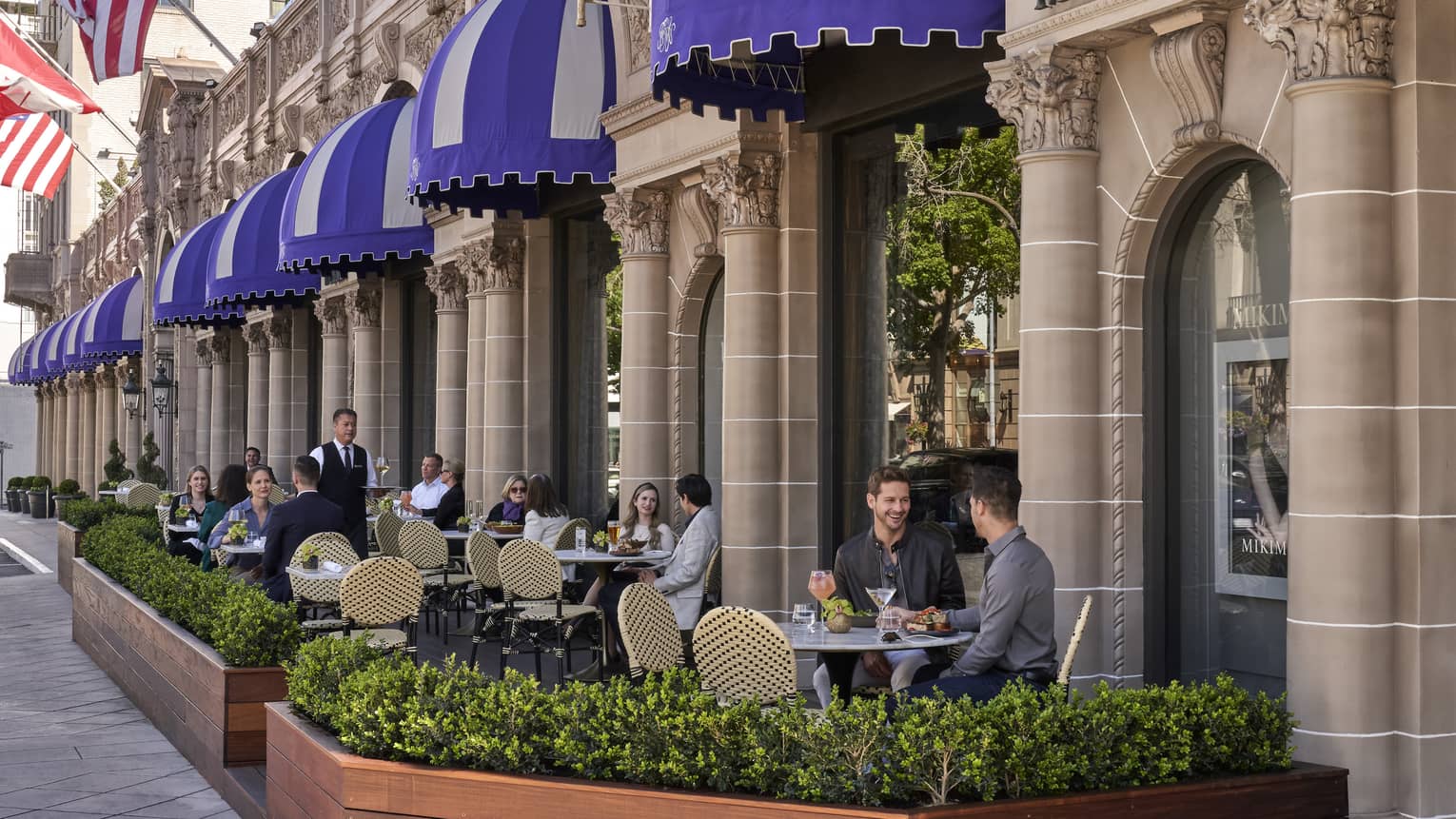 A patio eating area outside of a stone building.