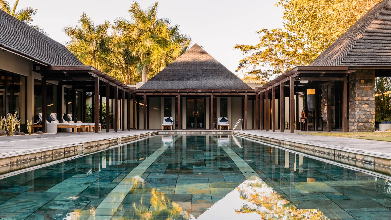Lap pool with clear water and tiled floor surrounded by patios and hotel buildings