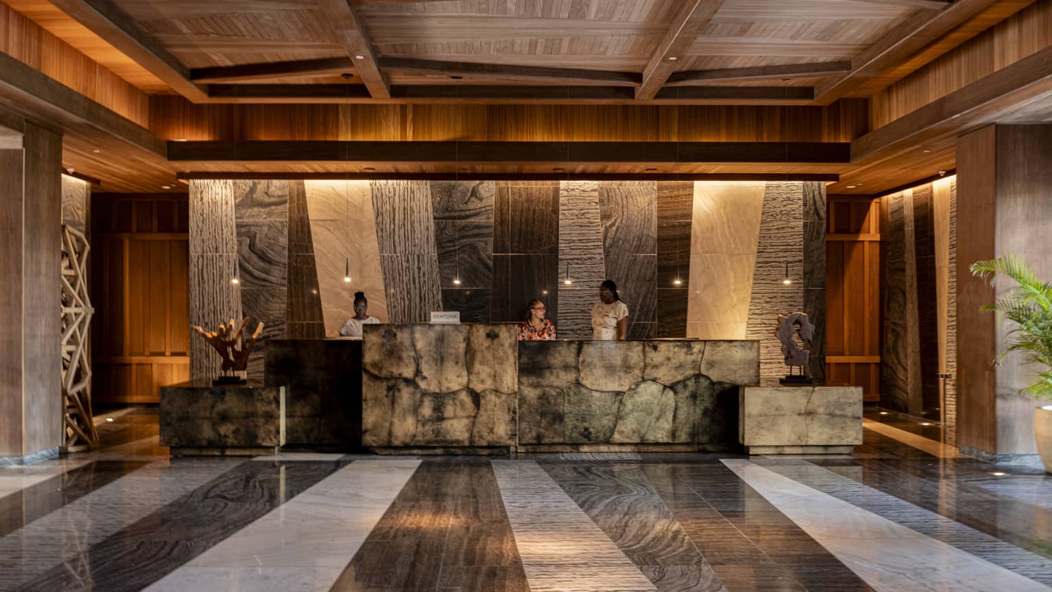 A warmly lit spacious lobby space with earth-toned decor and finishes