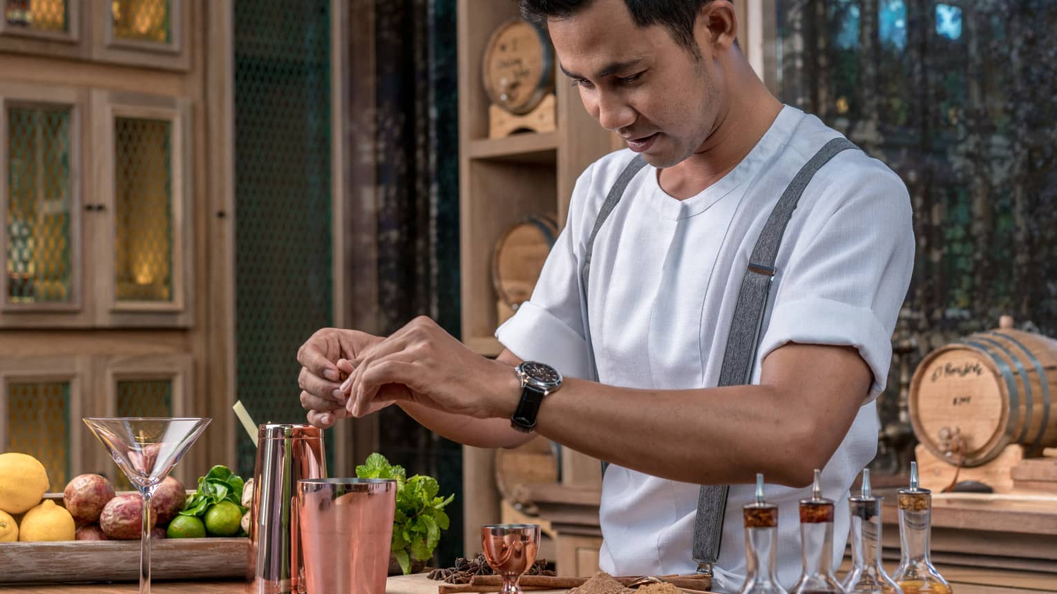 Bartender adds fragrant spices to a copper shaker in preparation for a cocktail 