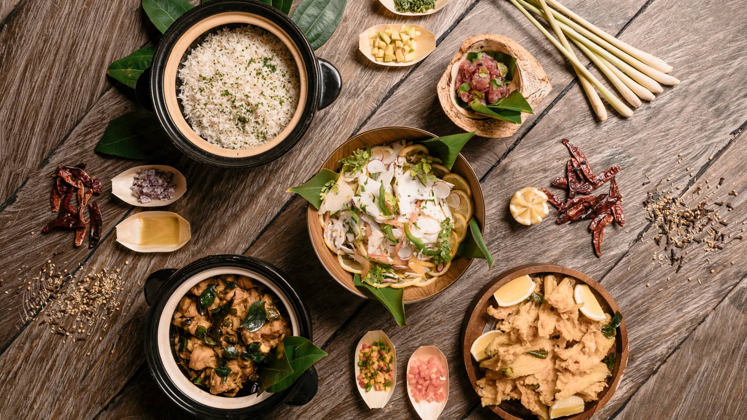 Aerial view of rustic wood table with bowls of gourmet rice, salads and entrees 