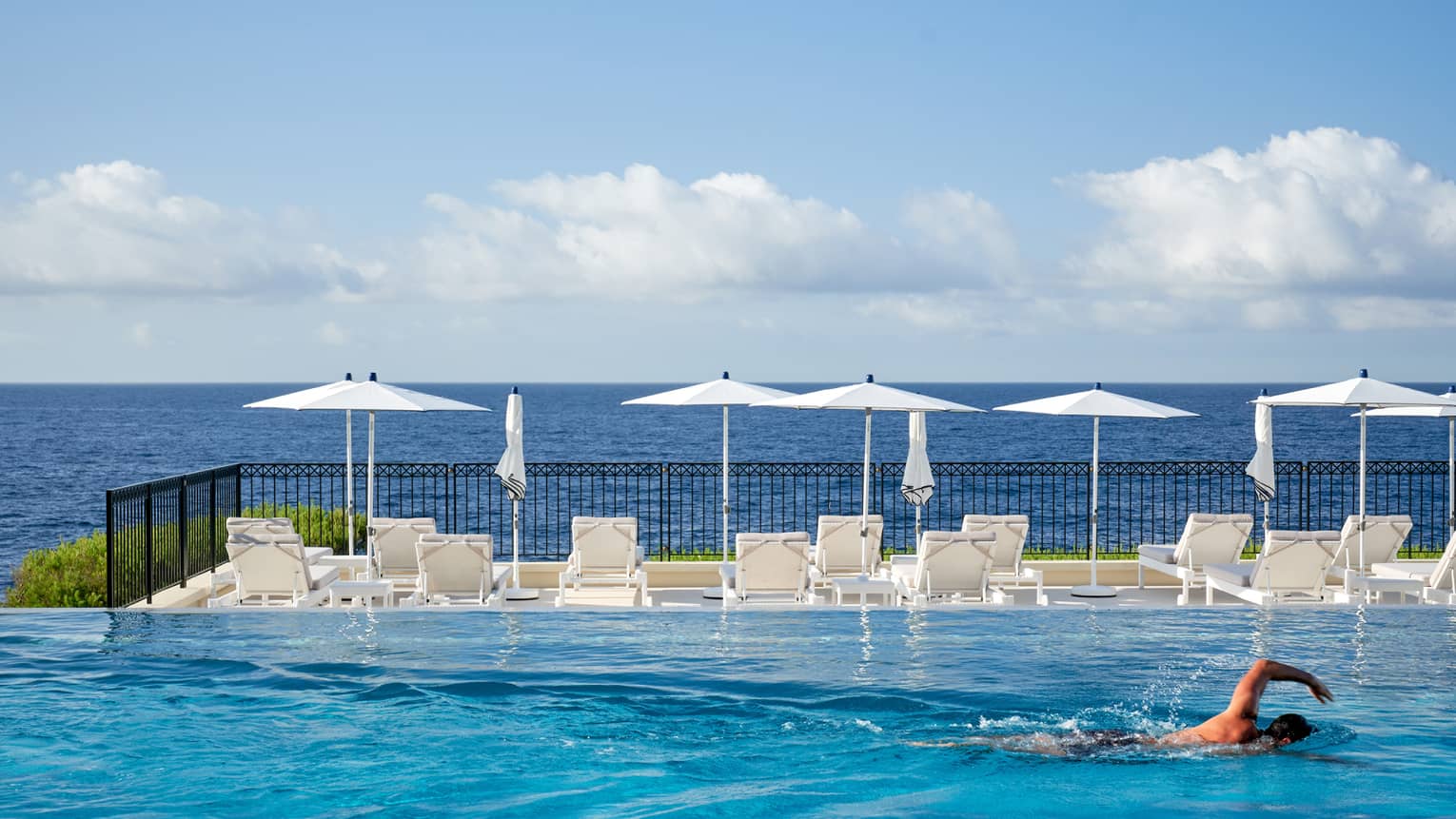 Man swimming in infinity pool