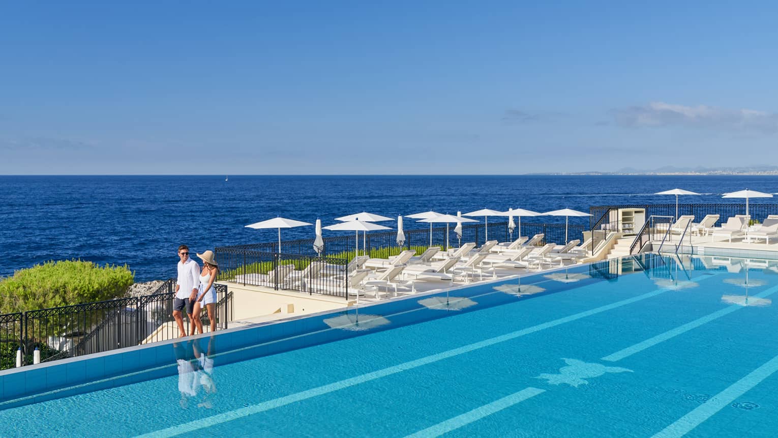 A couple walking around a luxury hotel pool