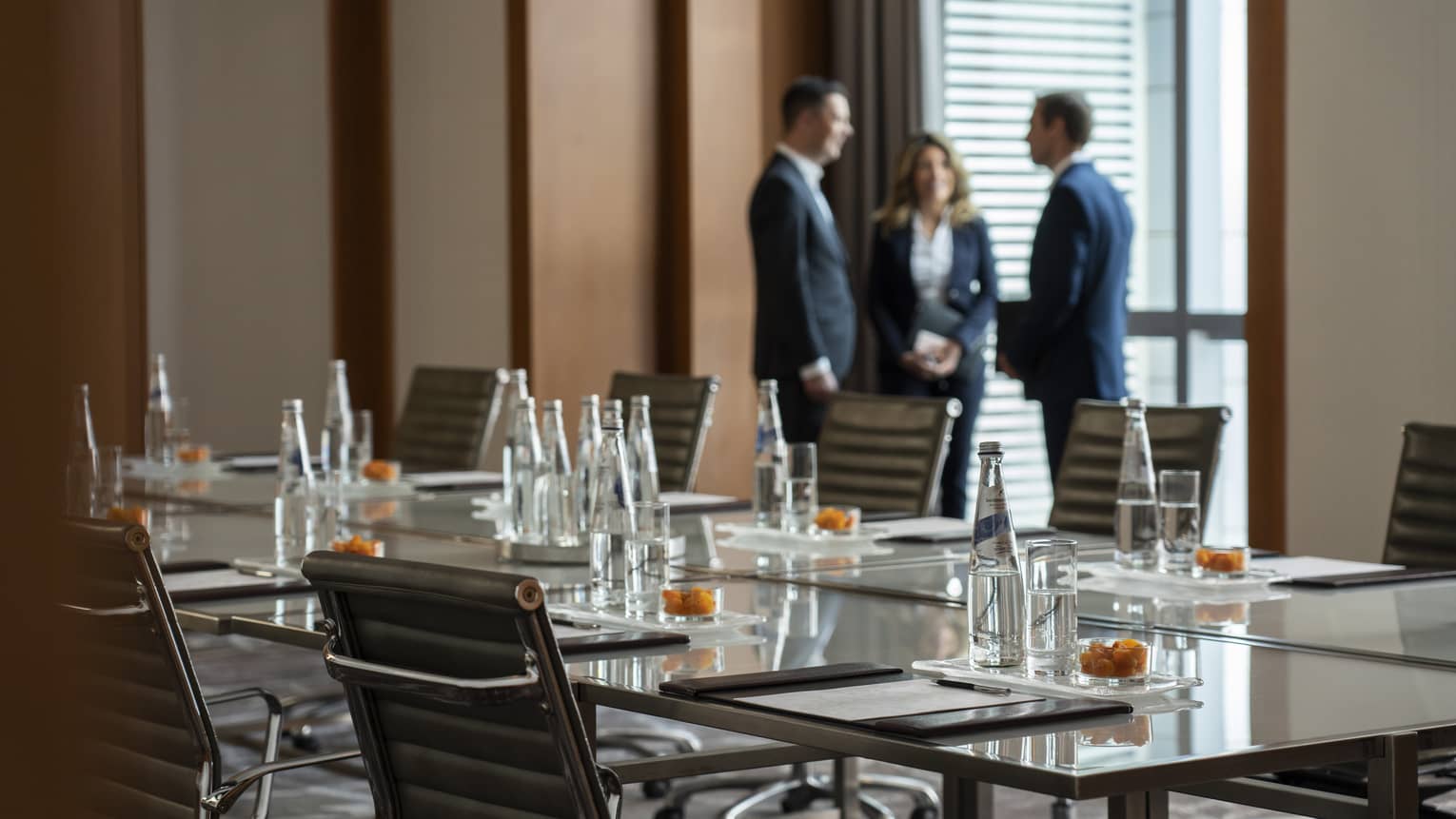 Three business people stand by window in Bal Harbour meeting room