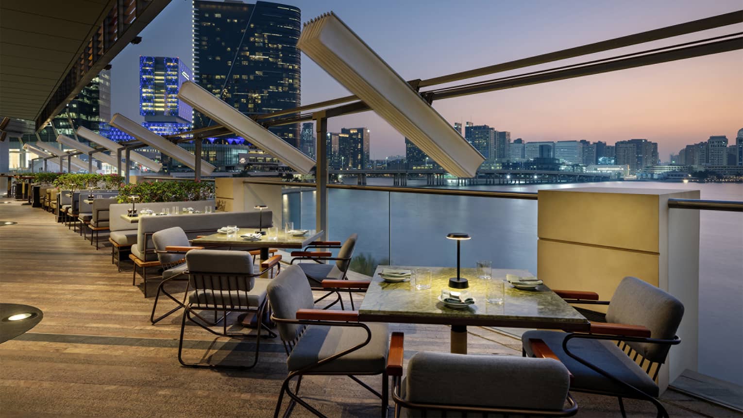 Restaurant terrace with tables overlooking the water at sunset
