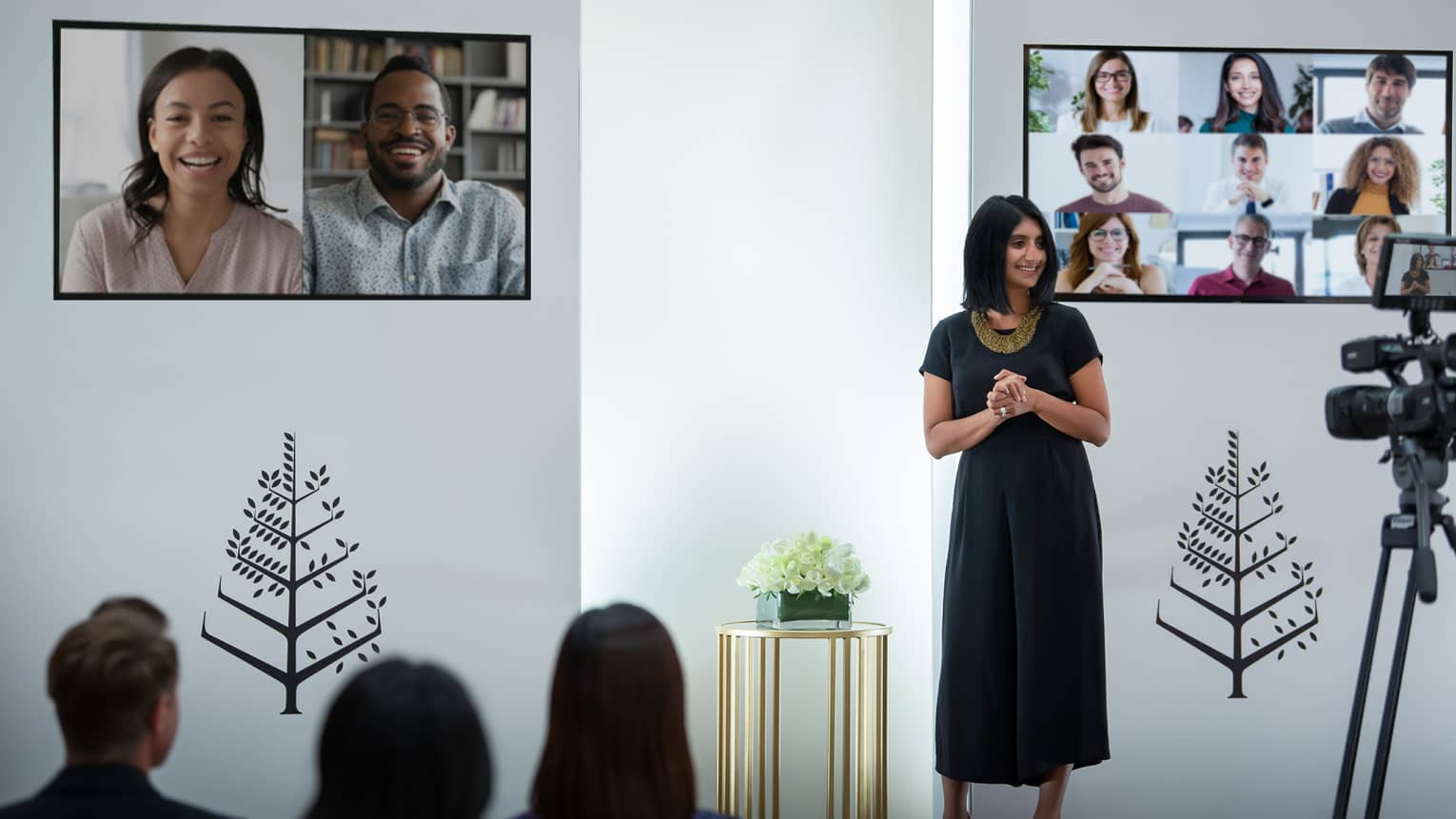 Several people host a virtual meeting in a room with the Four Seasons logo.