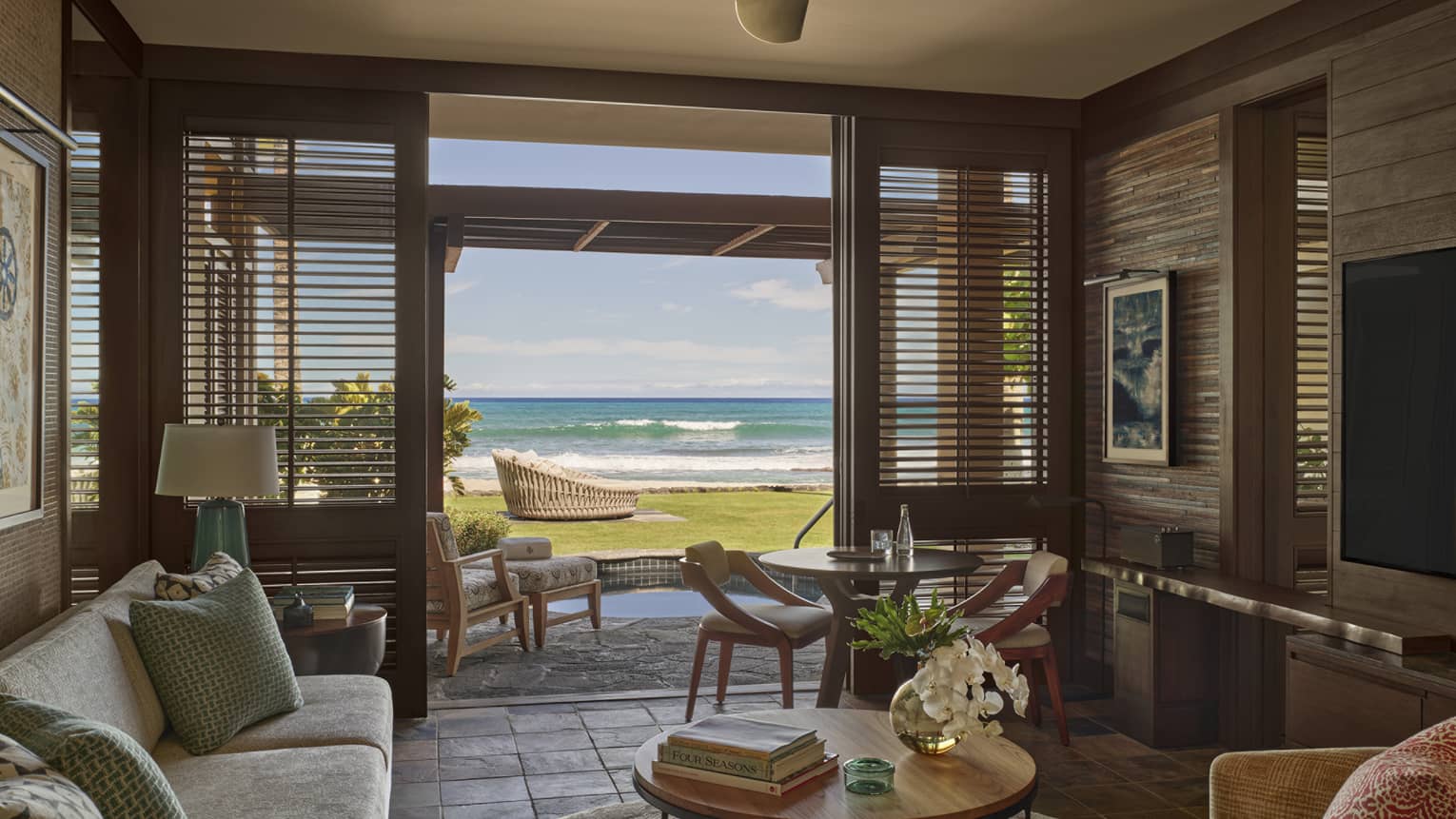 Living room in resort suite, opening to private terrace with ground-level beach view