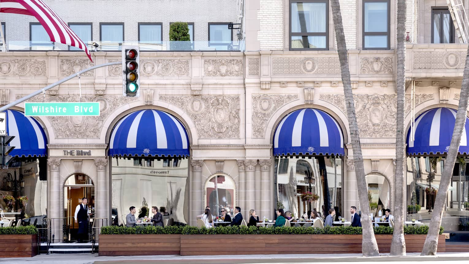 A patio where people are eating outside of a stone building.