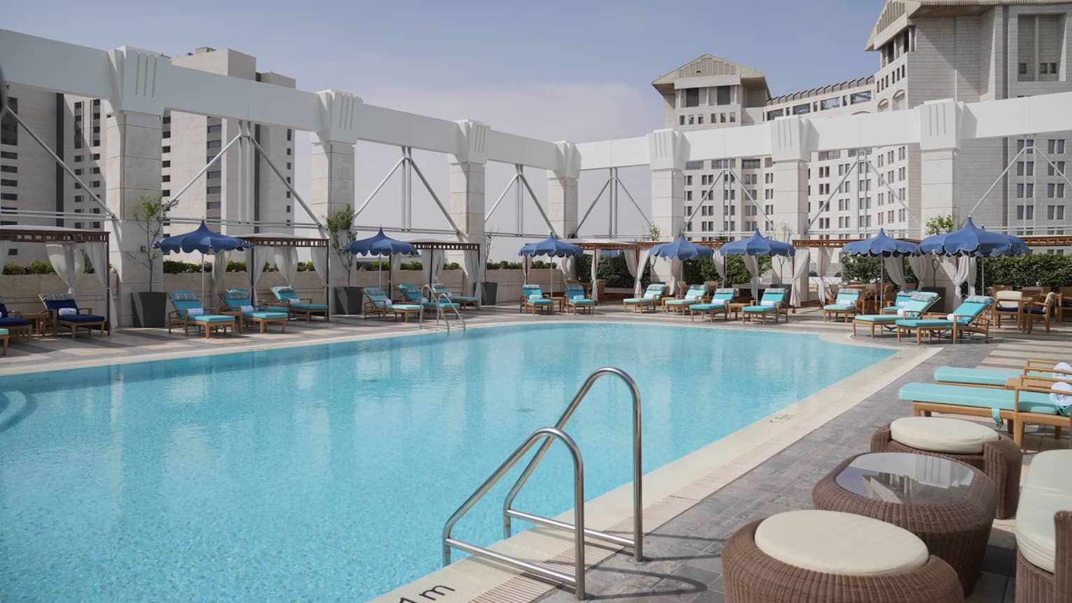 Rooftop pool surrounded by blue lounge chairs