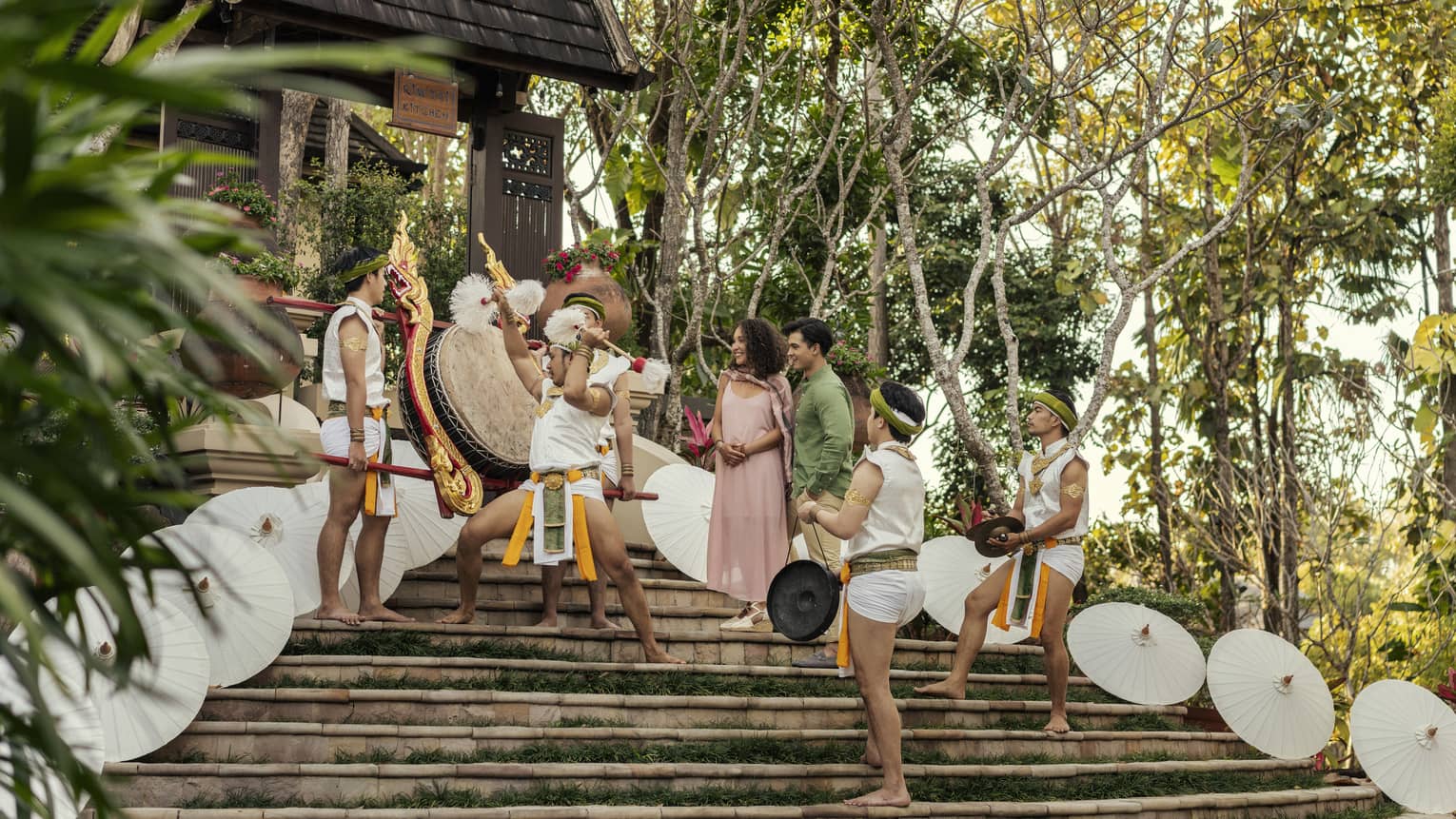 Traditional Lanna dancers perform for a couple on the steps of a temple