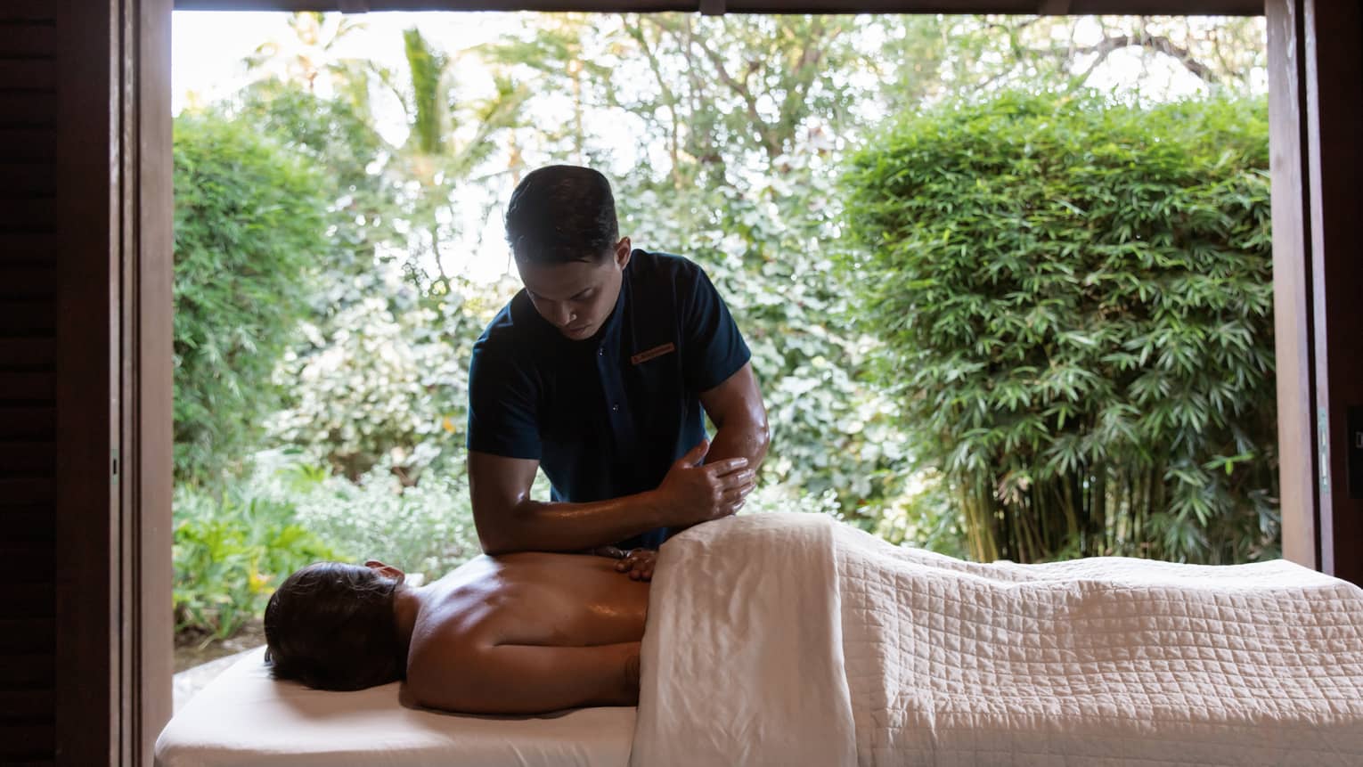Man performs massage with elbow on back