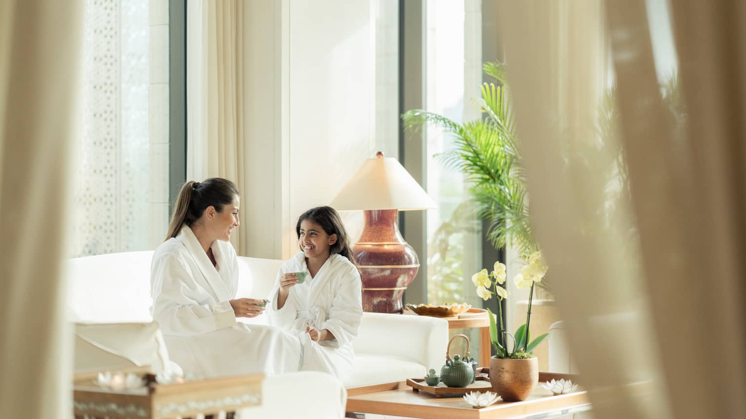 Mom and daughter enjoy tea in luxury hotel spa