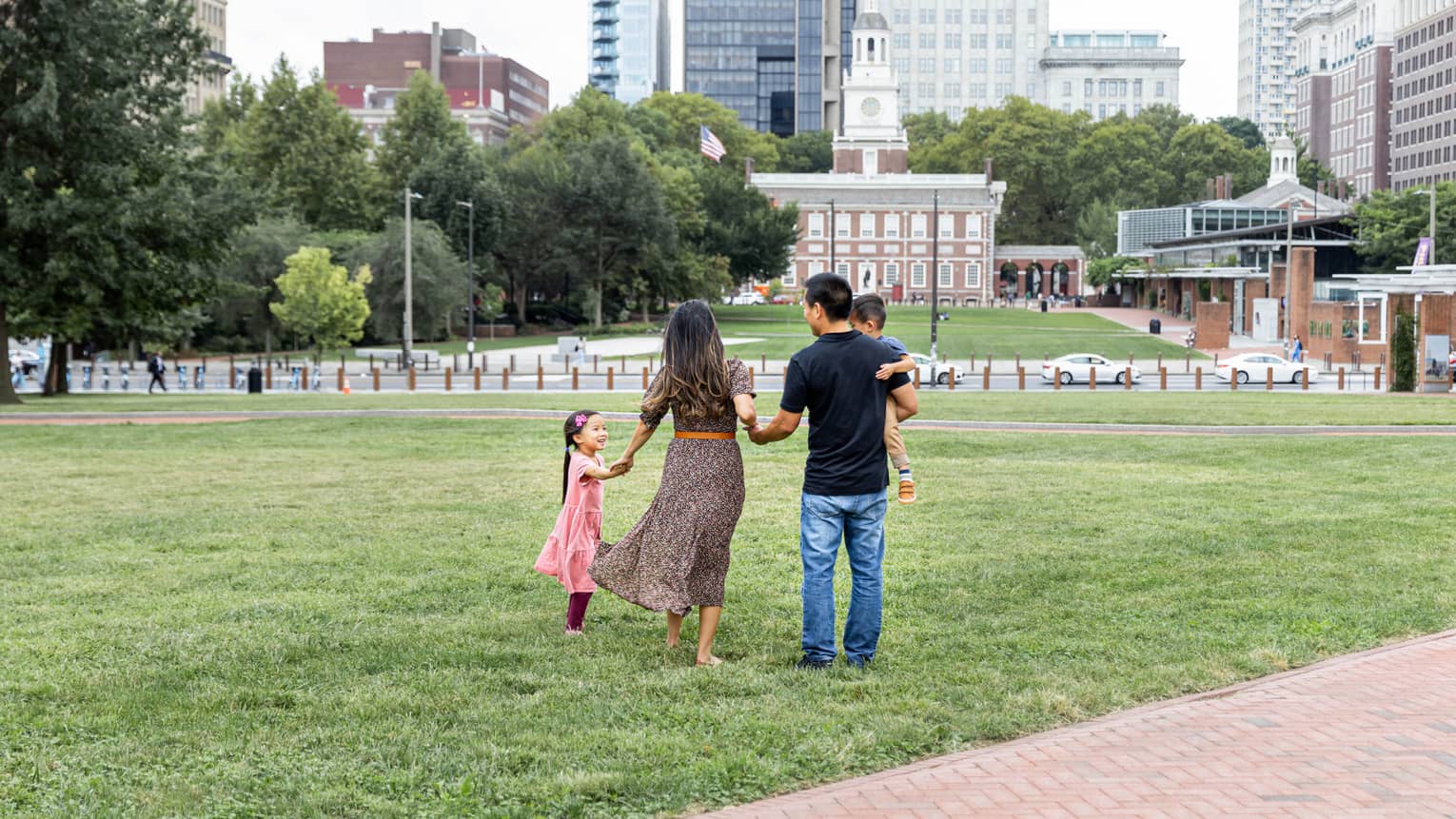 A family of four standing in a park in a city.