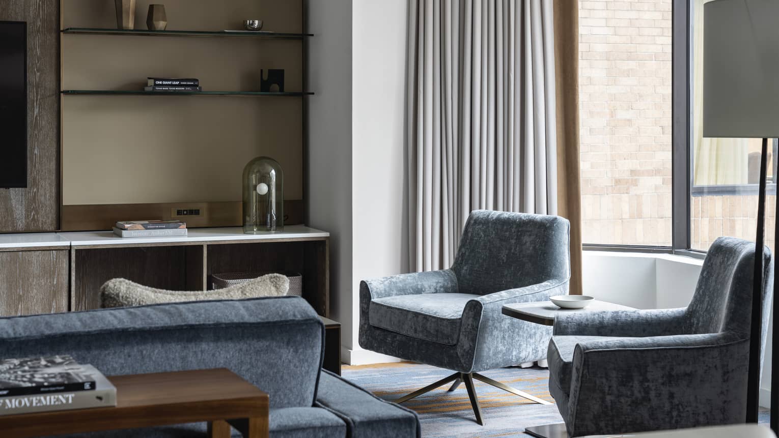 Residence at Four Seasons Hotel Houston, with shelving unit and light-blue chairs and couch near window