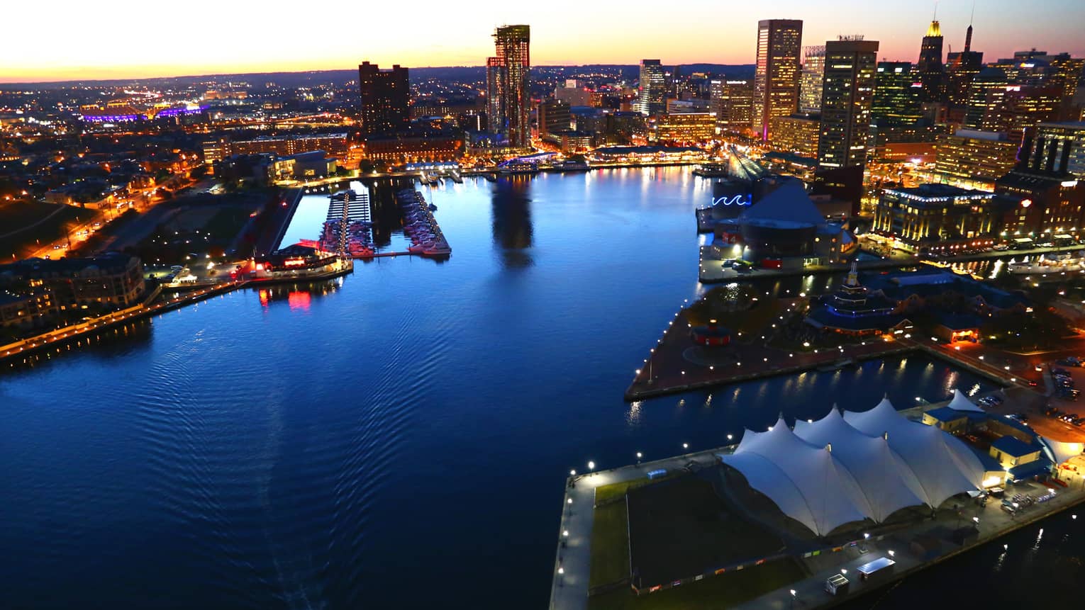 View of the harbour in Baltimore at dusk, surrounded by city lights