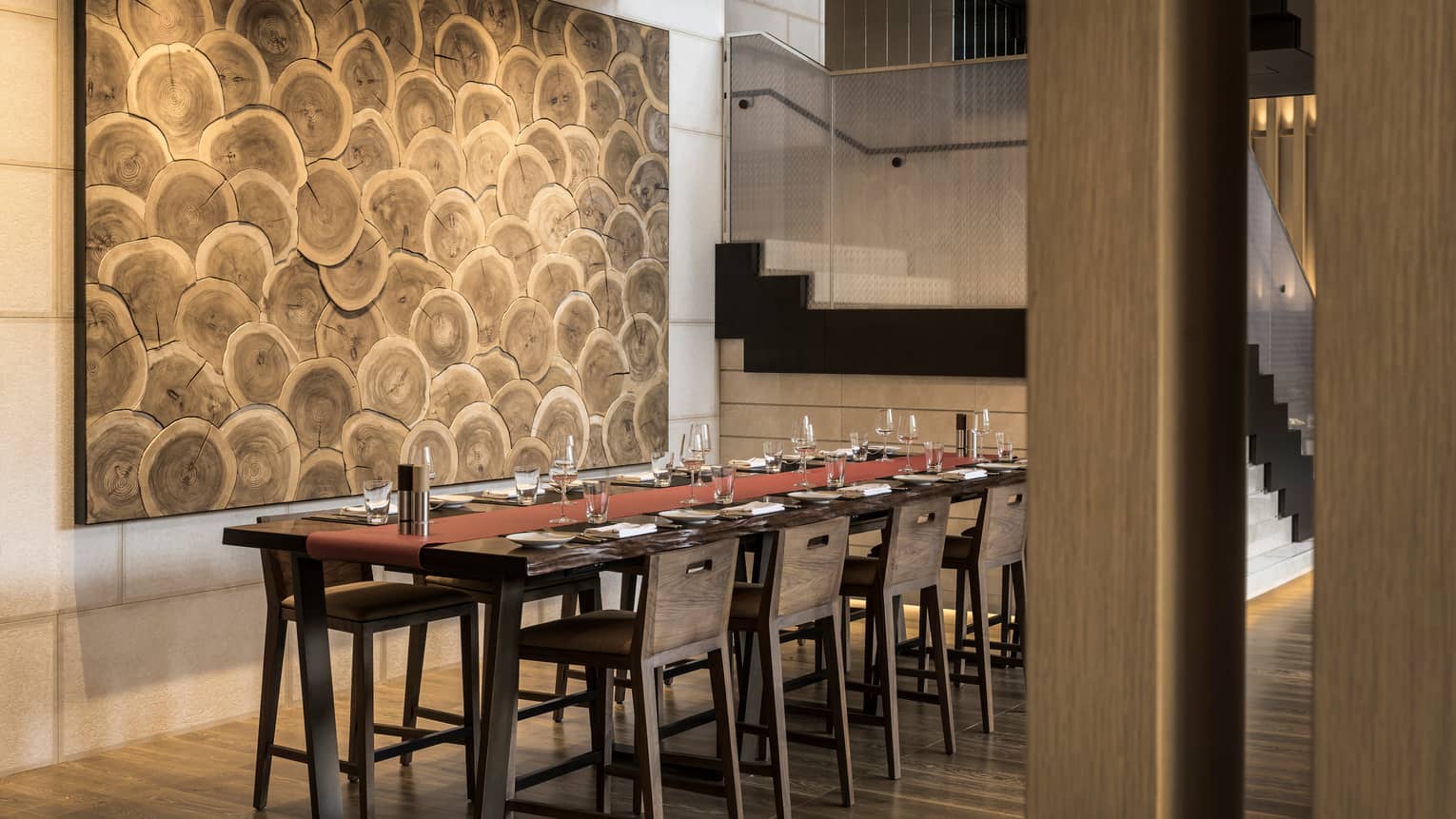 Brasserie long rustic wood dining table under large tree ring mural
