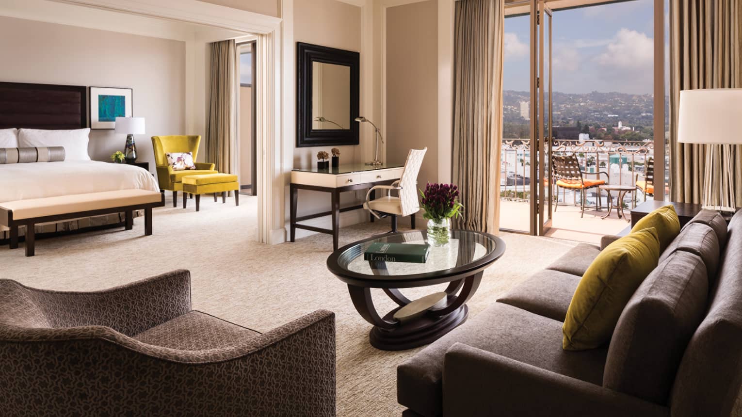 Beverly Presidential Suite seating area, desk by open balcony door, adjoining room with bed, chair